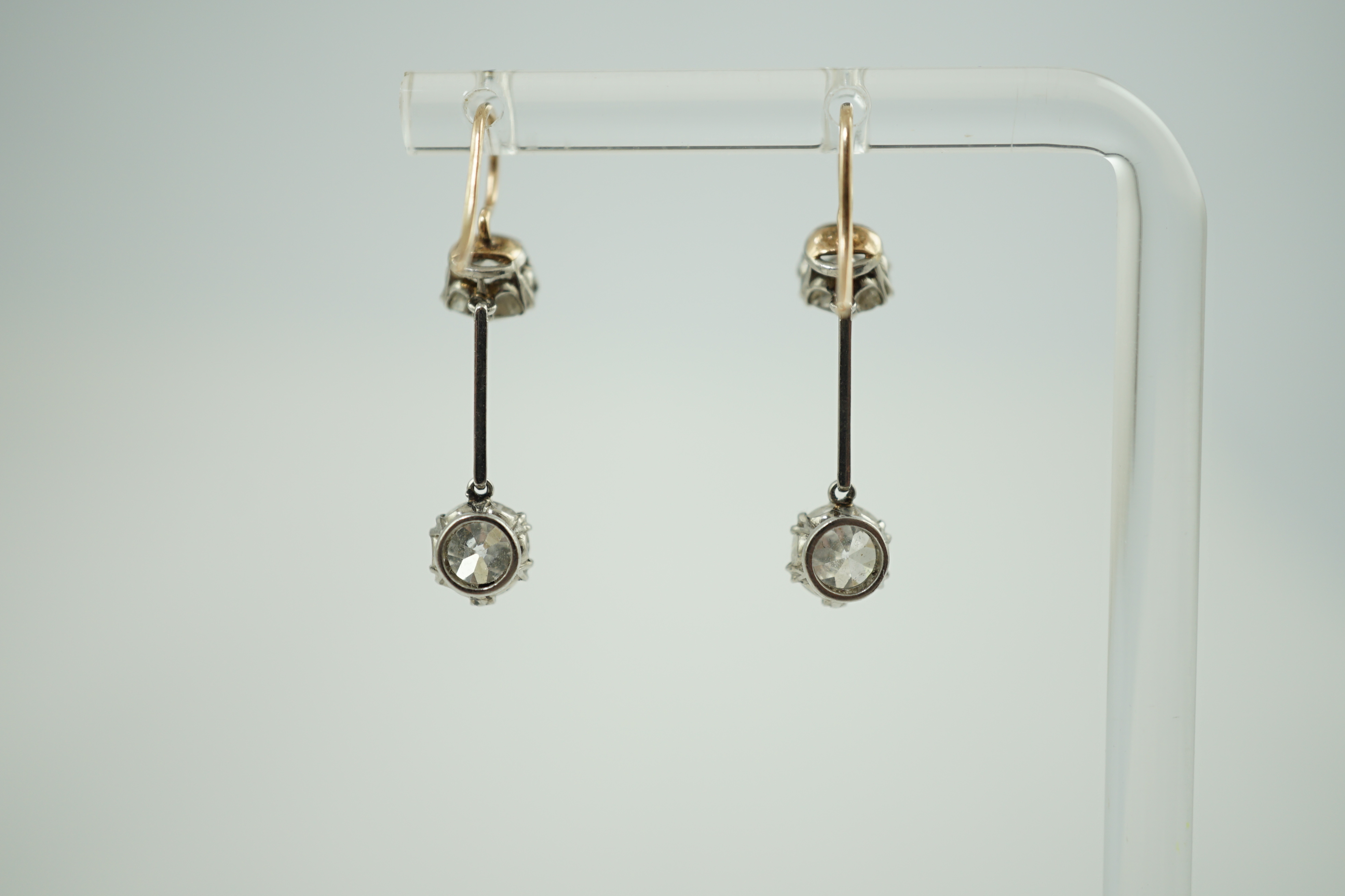 A pair of gold and graduated two stone diamond set drop earrings